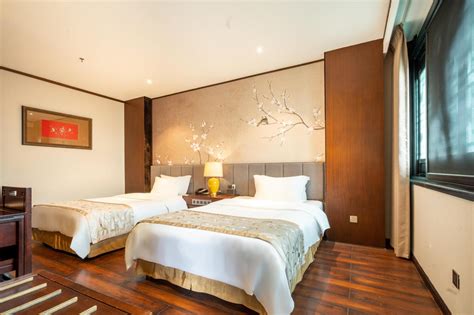 Kamer met twee bedden en een muurschildering van bloesems en vogels