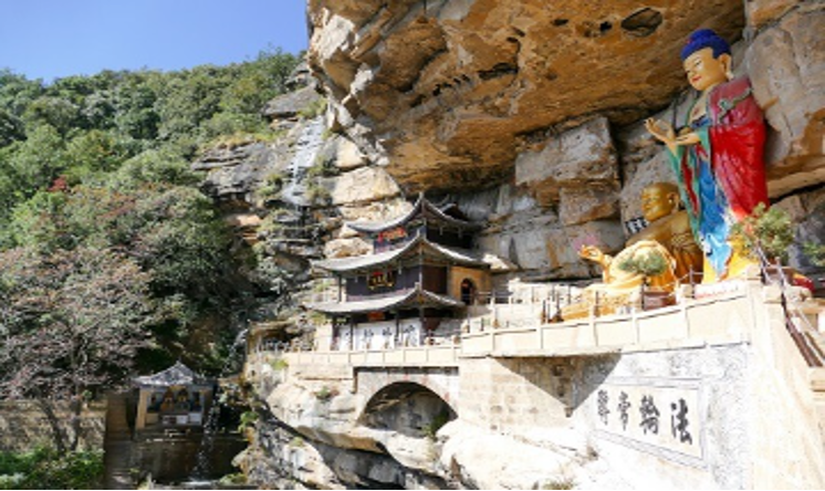 Boeddhistische tempel en grote beelden onder een overhangende klif bij Shibaoshan